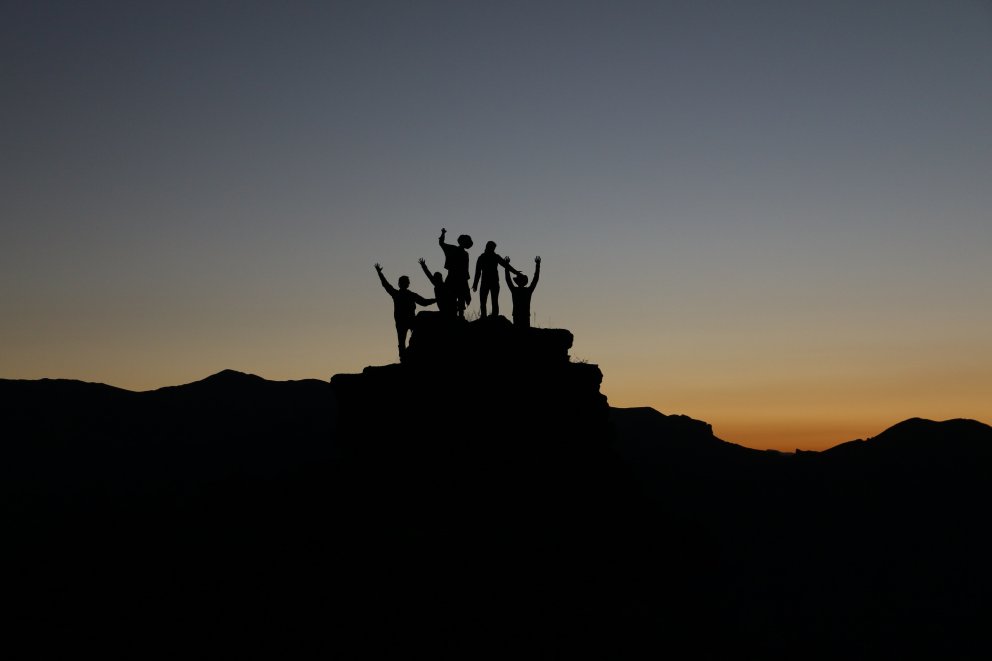 people on top of mountain sunset
