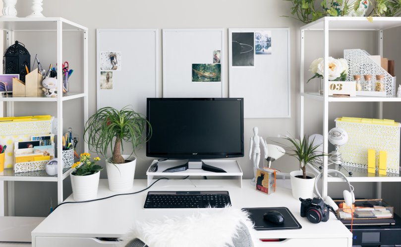 monitor on white office work desk white office furniture green plants