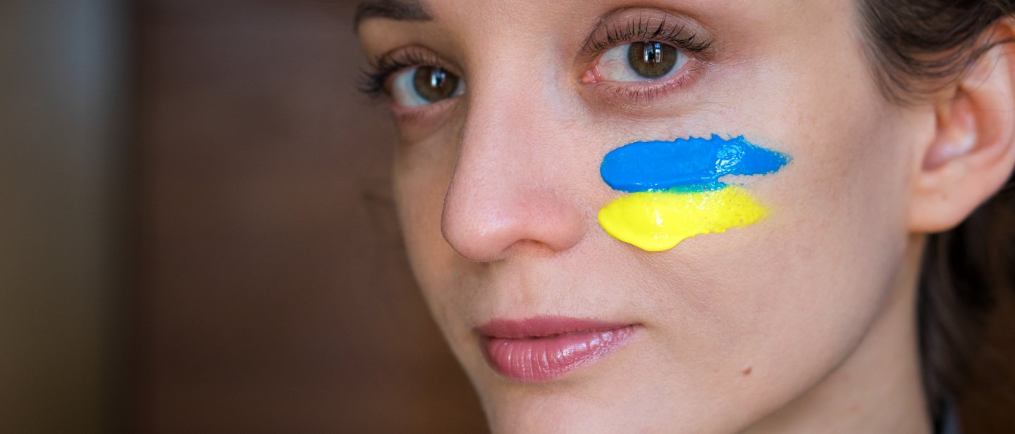 Frau mit Ukraine Flagge im Gesicht