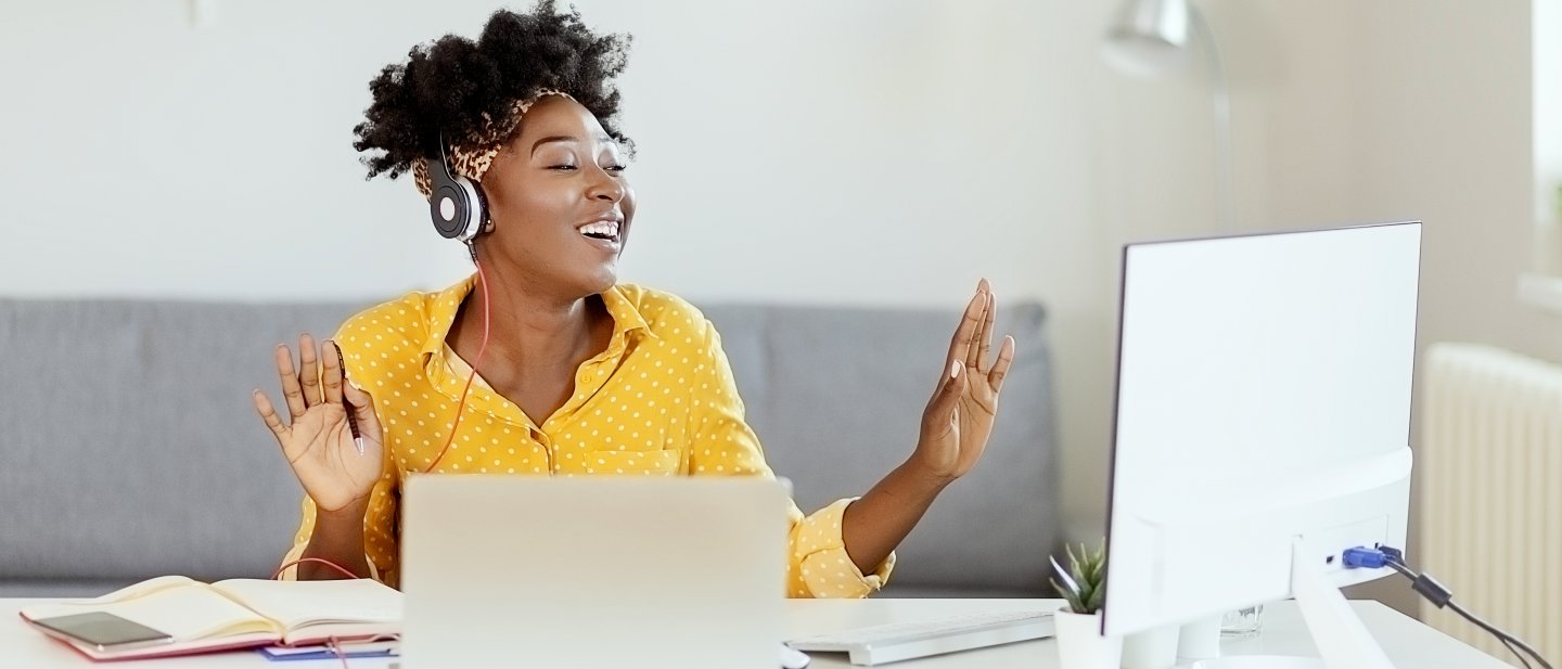 Frau hört Musik bei der Arbeit am Laptop